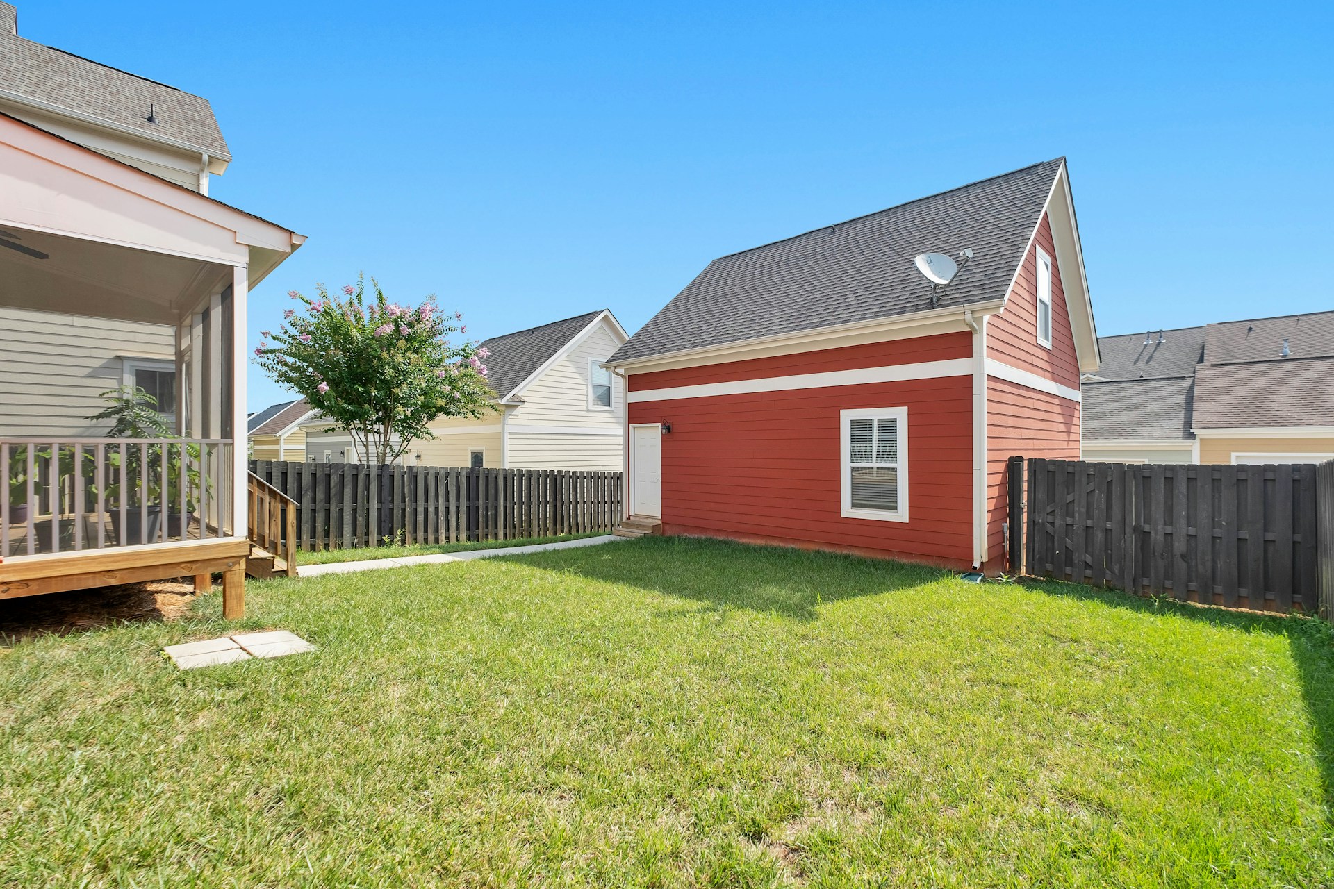 Clean, well-maintained fenced residential backyard with healthy green grass